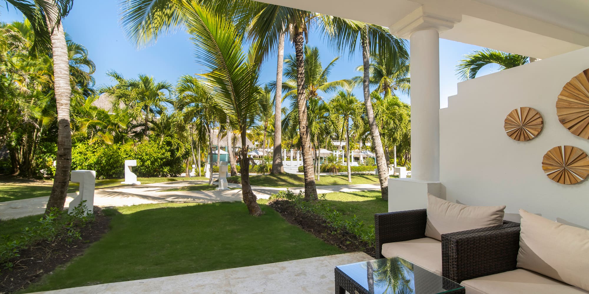 a patio with a table and chairs and palm trees