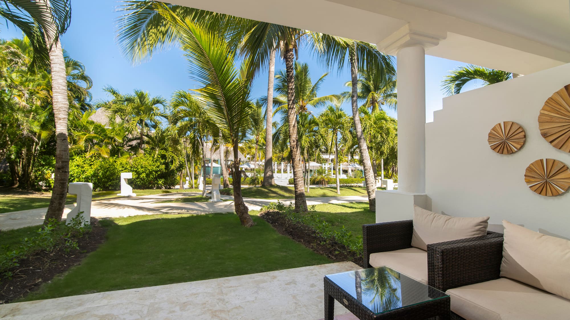a patio with a table and chairs and palm trees