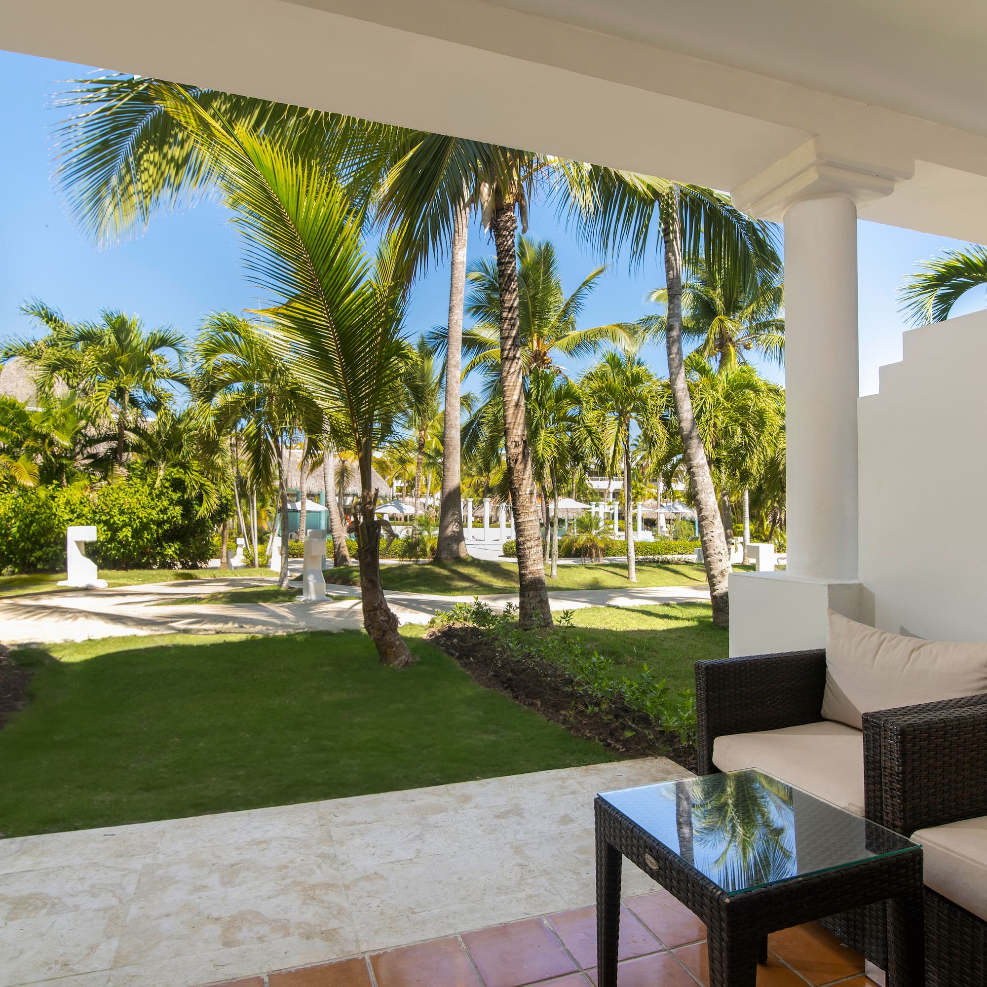 a patio with a table and chairs and palm trees