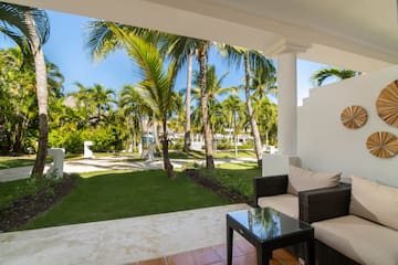 a patio with a table and chairs and palm trees