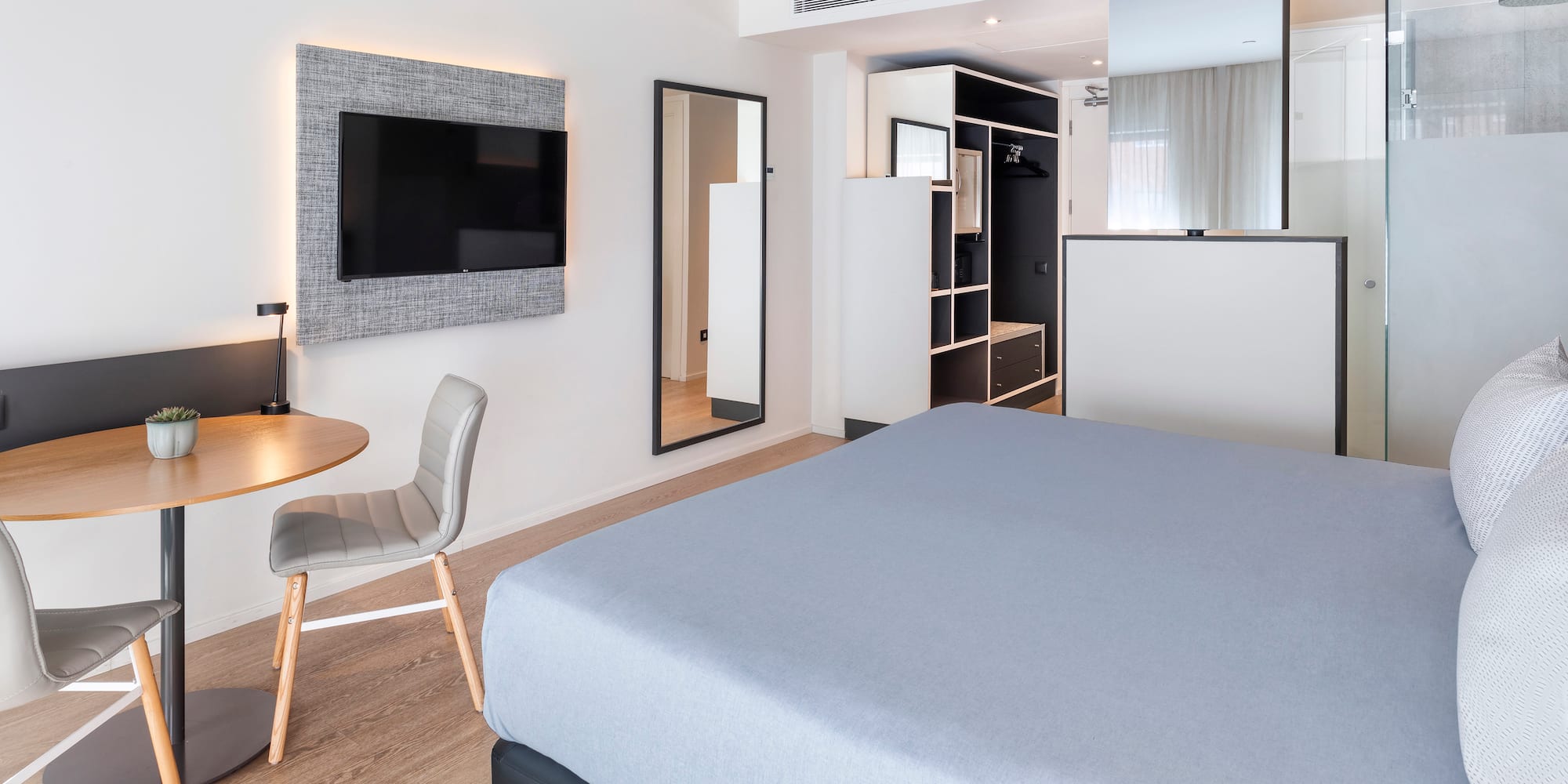 a room with a bed and a table and a tv