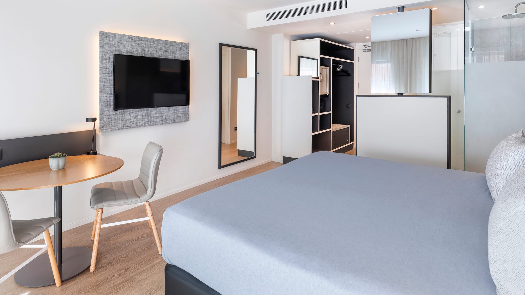 a room with a bed and a table and a tv