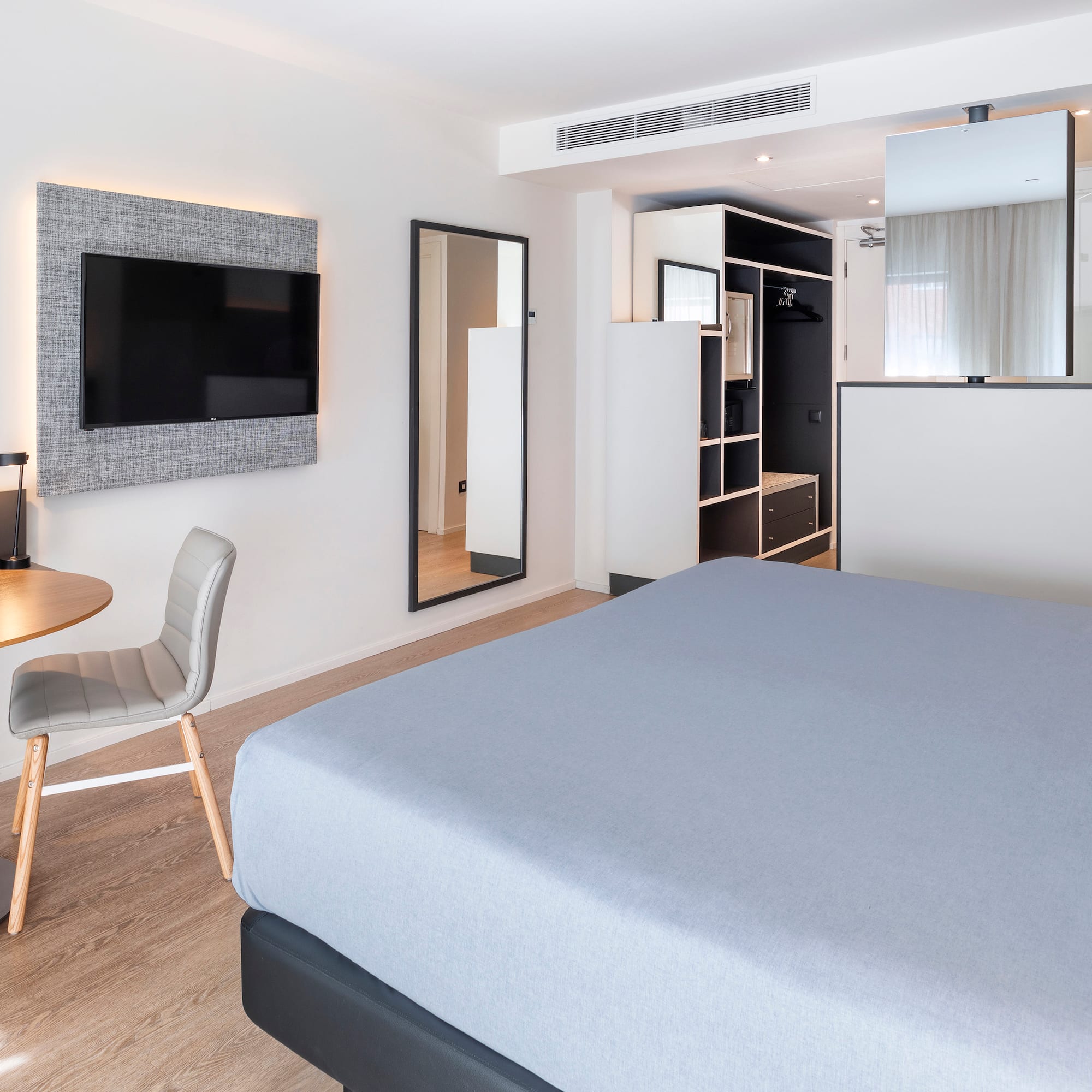 a room with a bed and a table and a tv