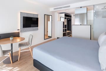 a room with a bed and a table and a tv