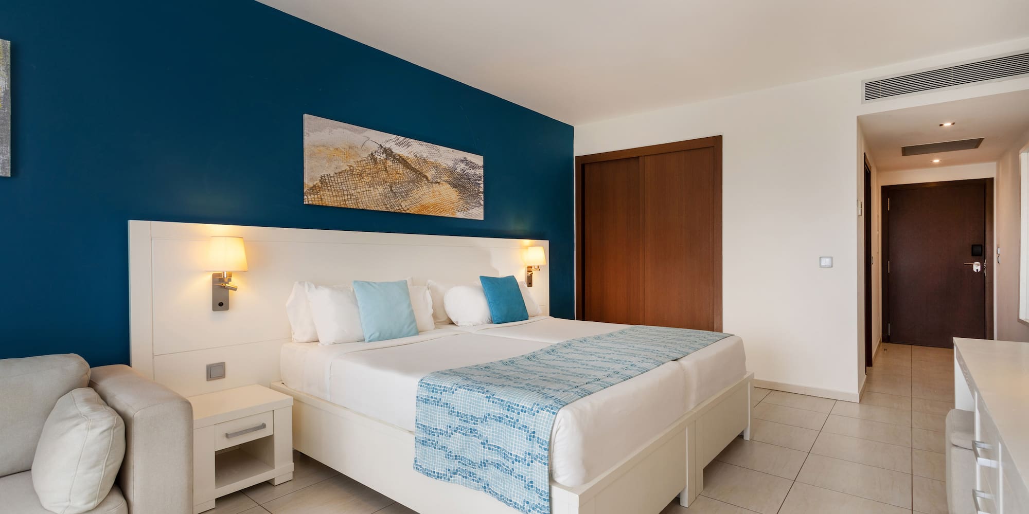 a bedroom with a bed and a blue wall