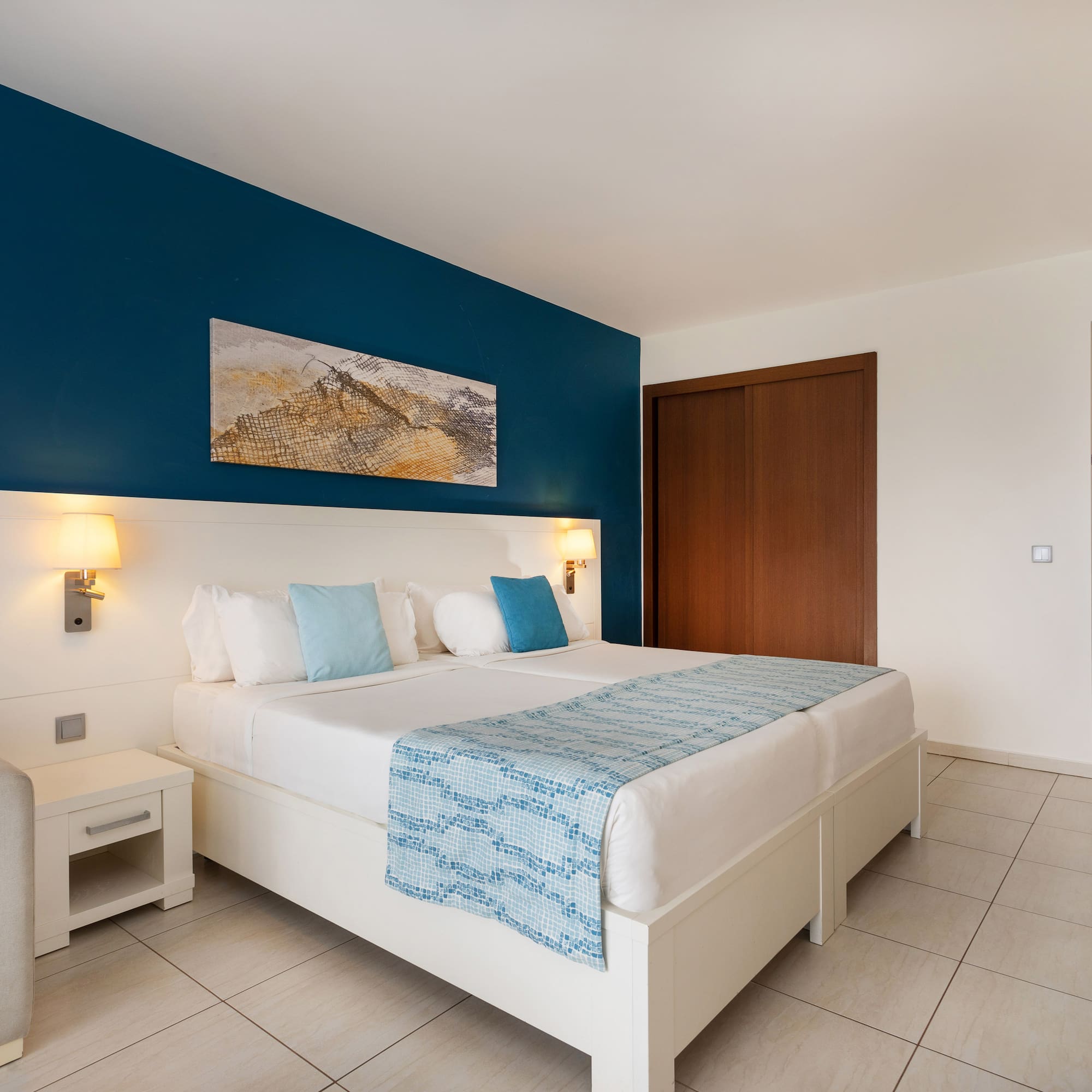 a bedroom with a bed and a blue wall