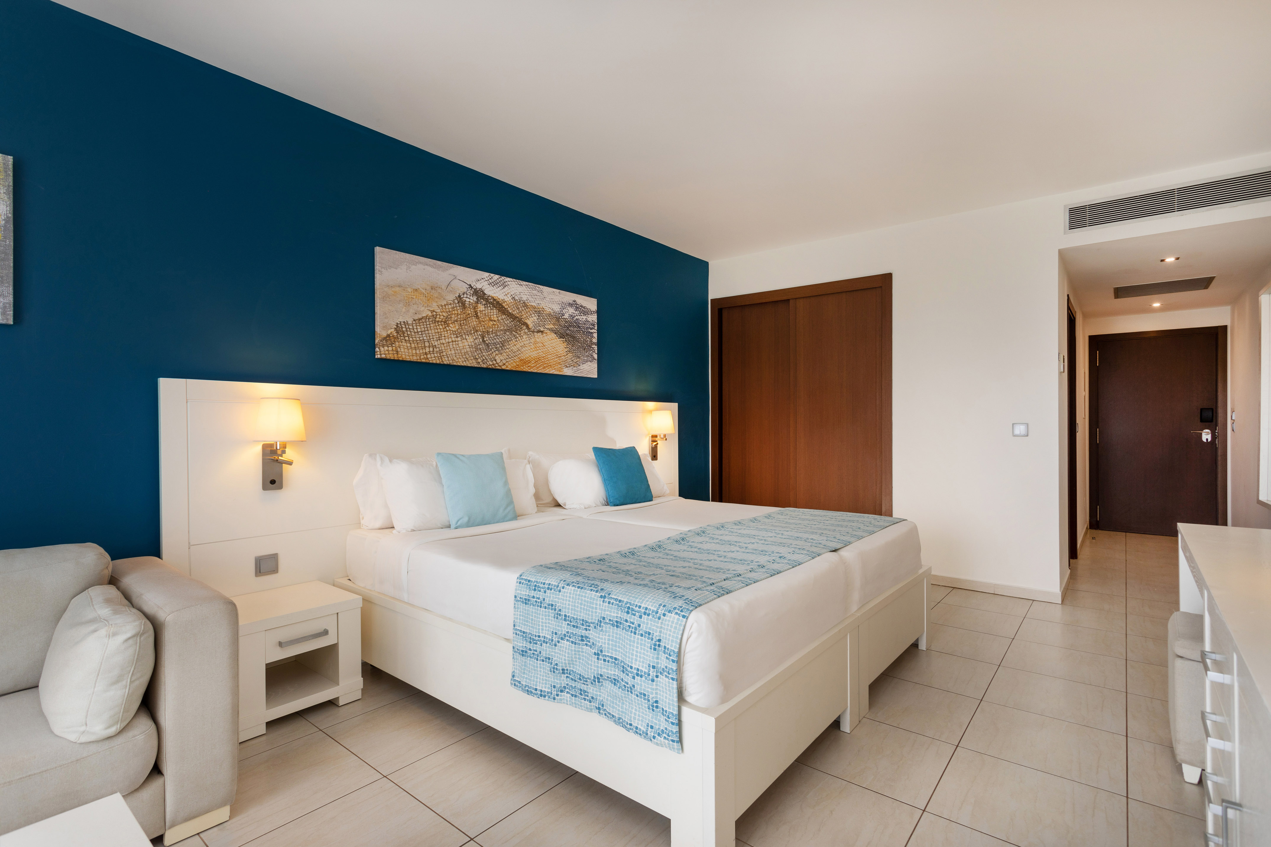 a bedroom with a bed and a blue wall