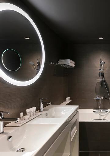 a bathroom with a round mirror