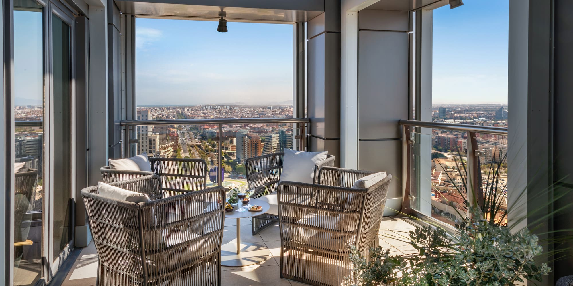 a patio area with chairs and a table and plants