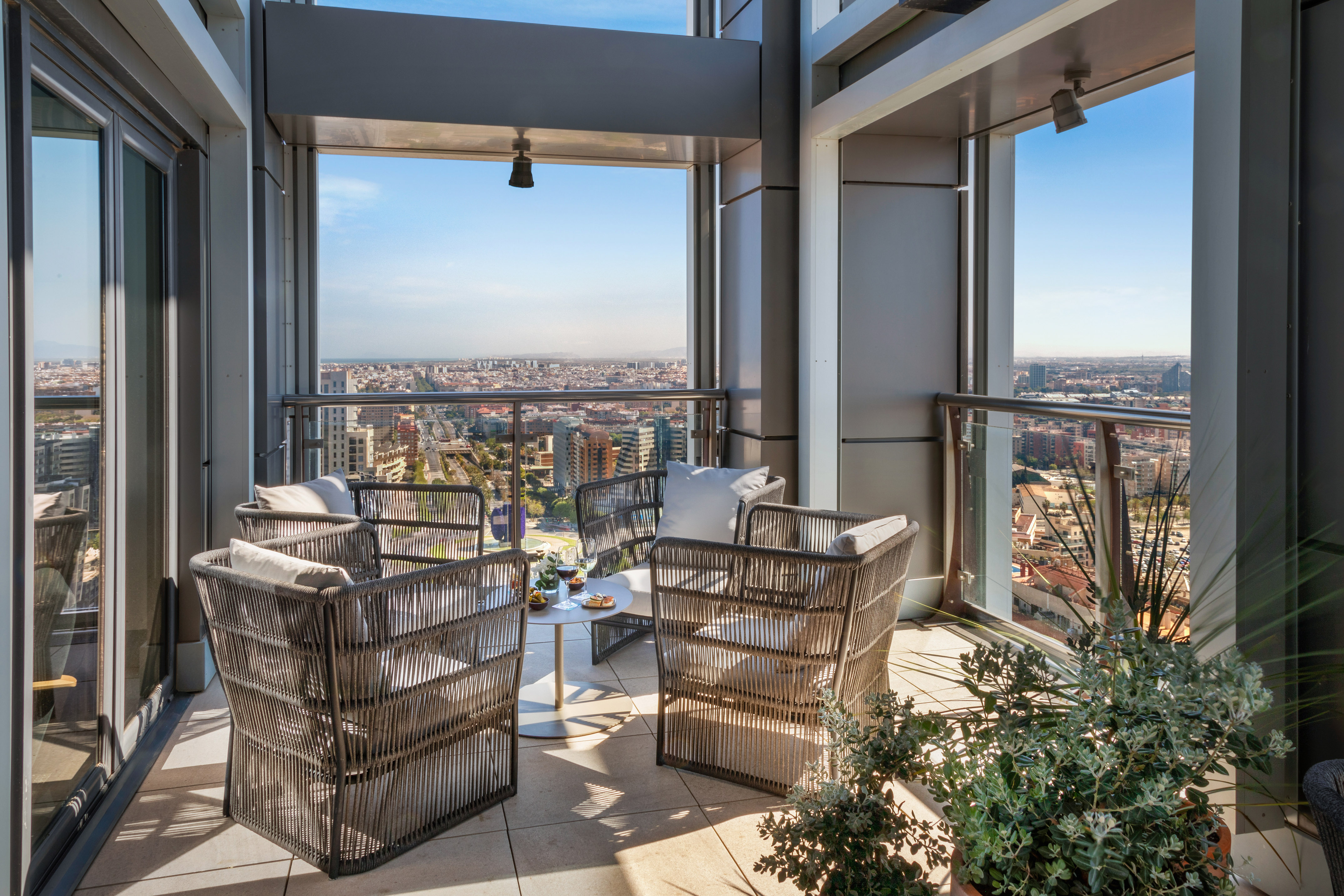 a patio area with chairs and a table and plants