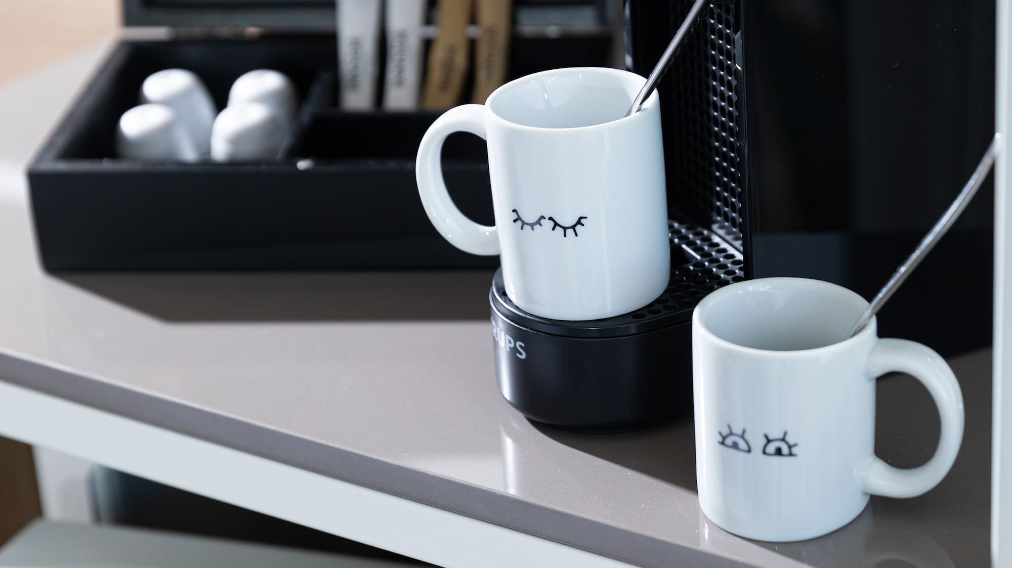 a coffee machine and mugs on a table