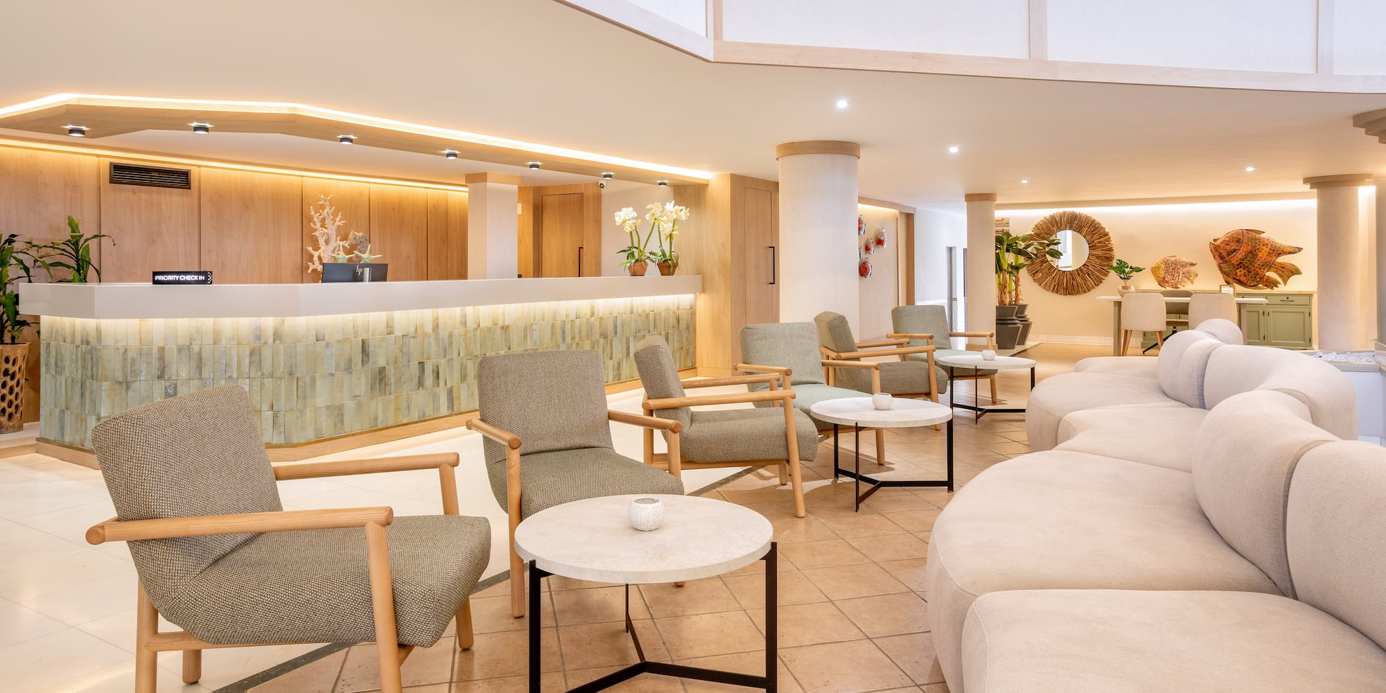 Modern resort lobby with priority check-in desk and comfortable lounge chairs.