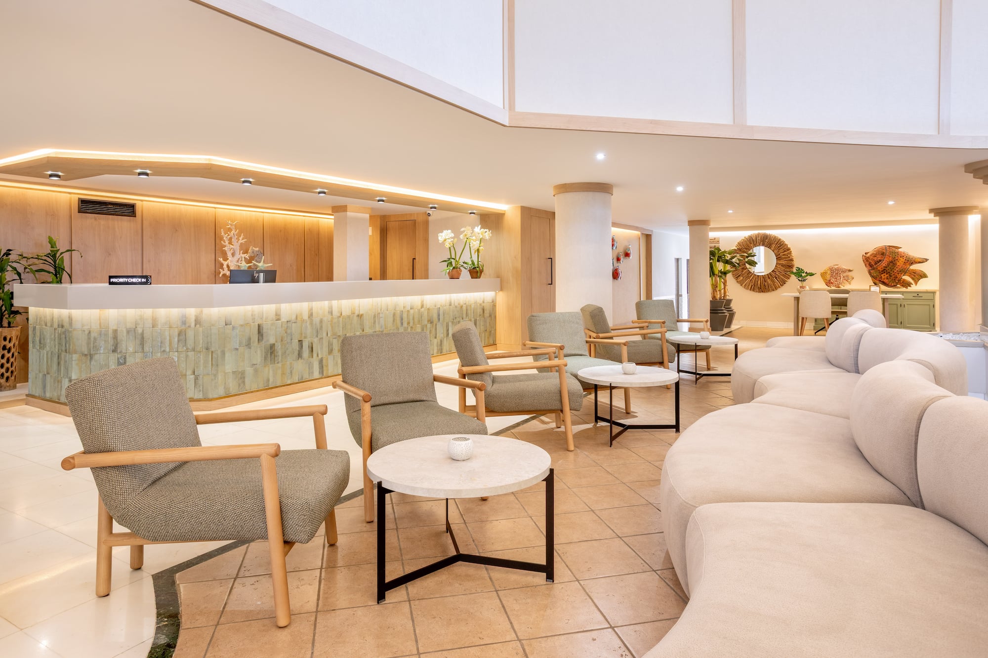 Modern resort lobby with priority check-in desk and comfortable lounge chairs.