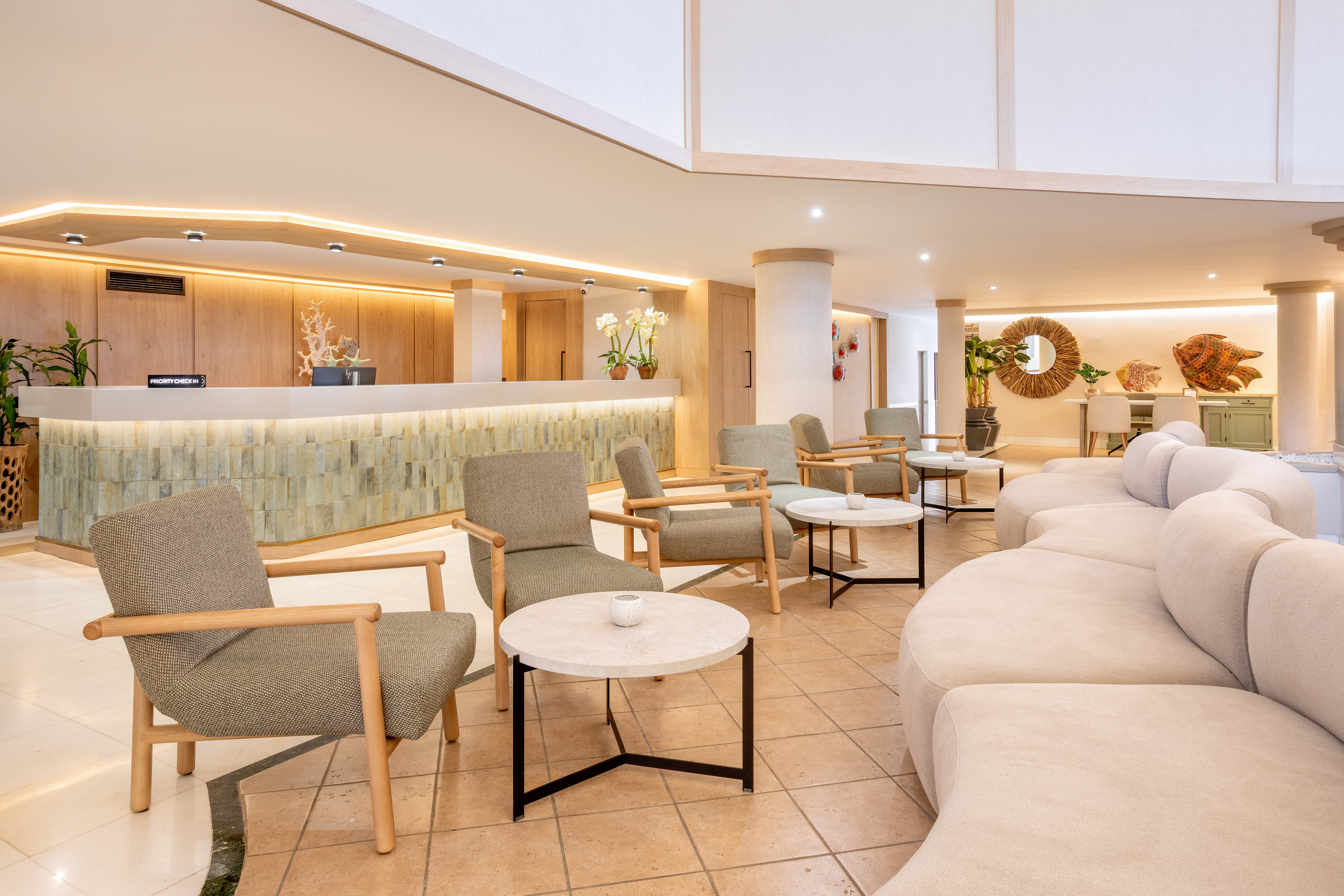Modern resort lobby with priority check-in desk and comfortable lounge chairs.