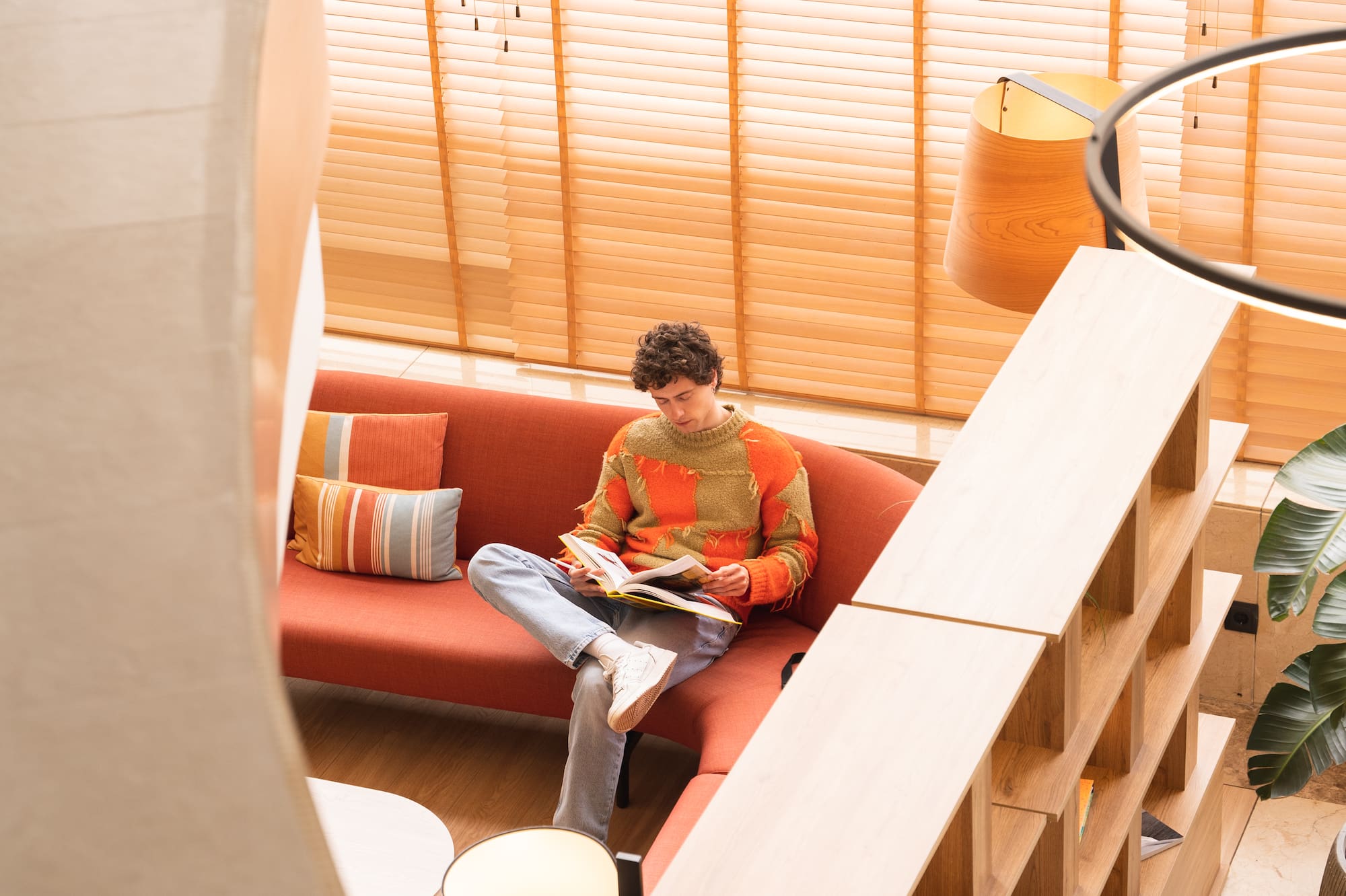 a man sitting on a couch reading a book