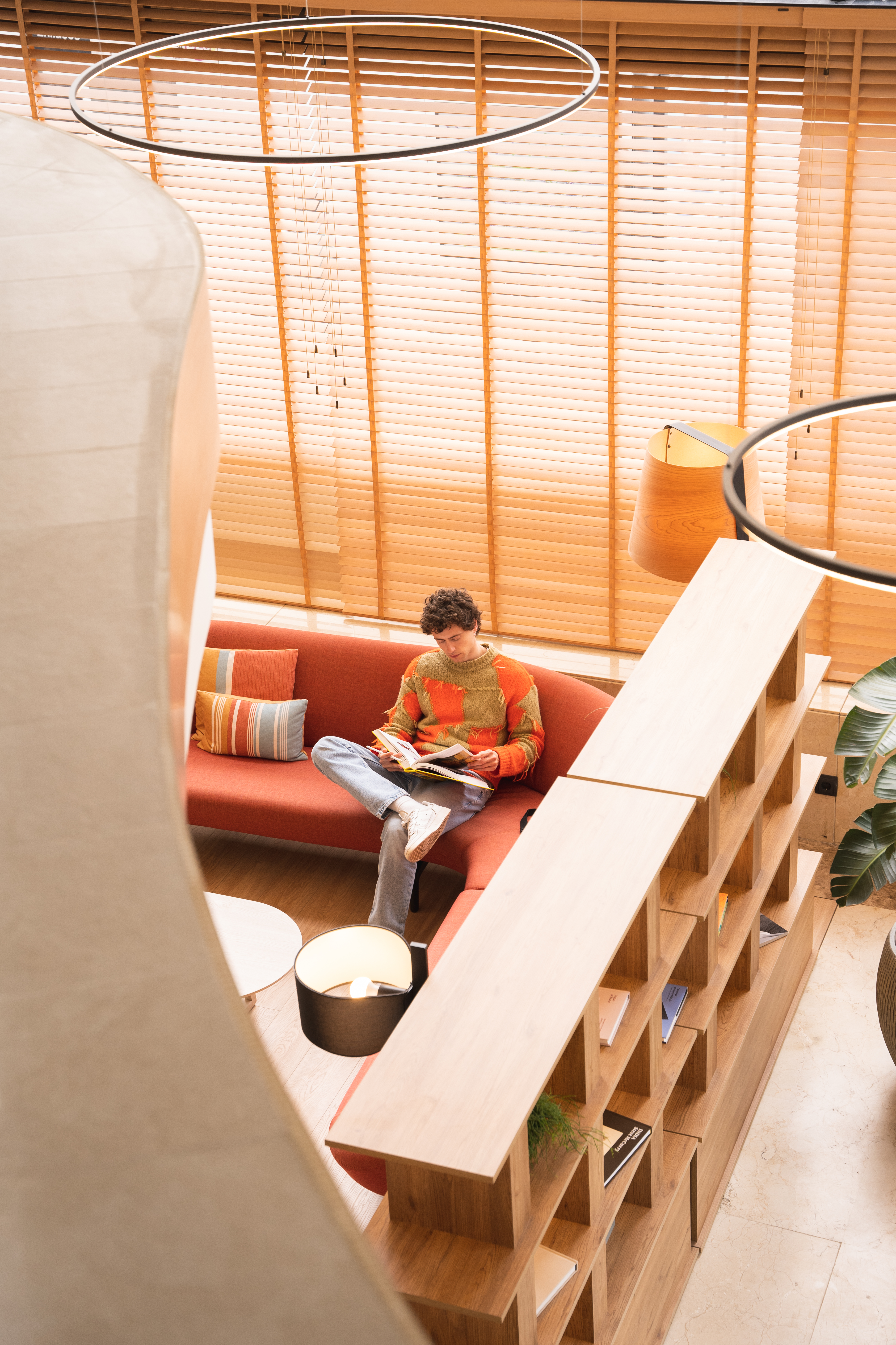 a man sitting on a couch reading a book