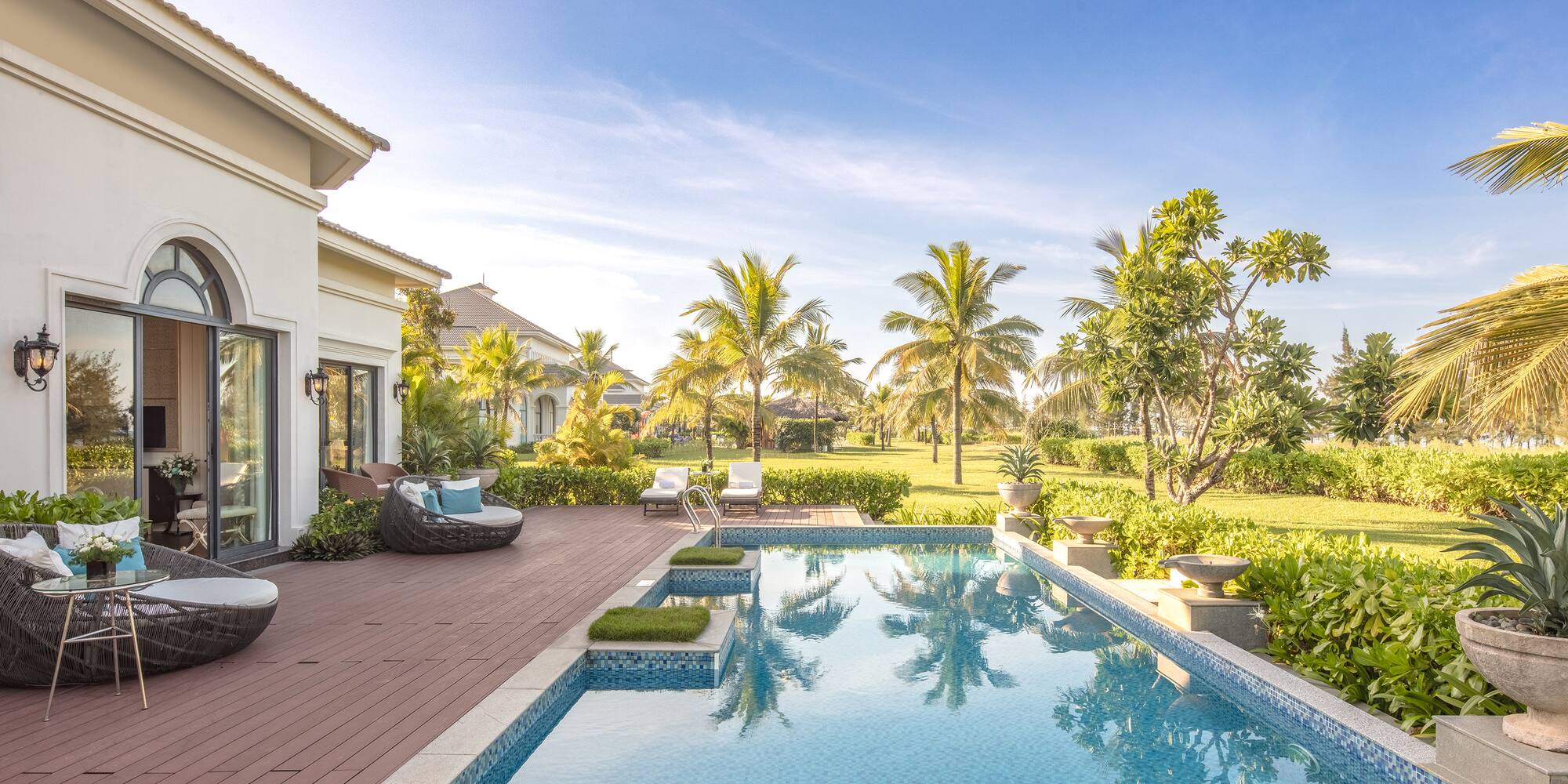 a pool with a deck and trees in the back