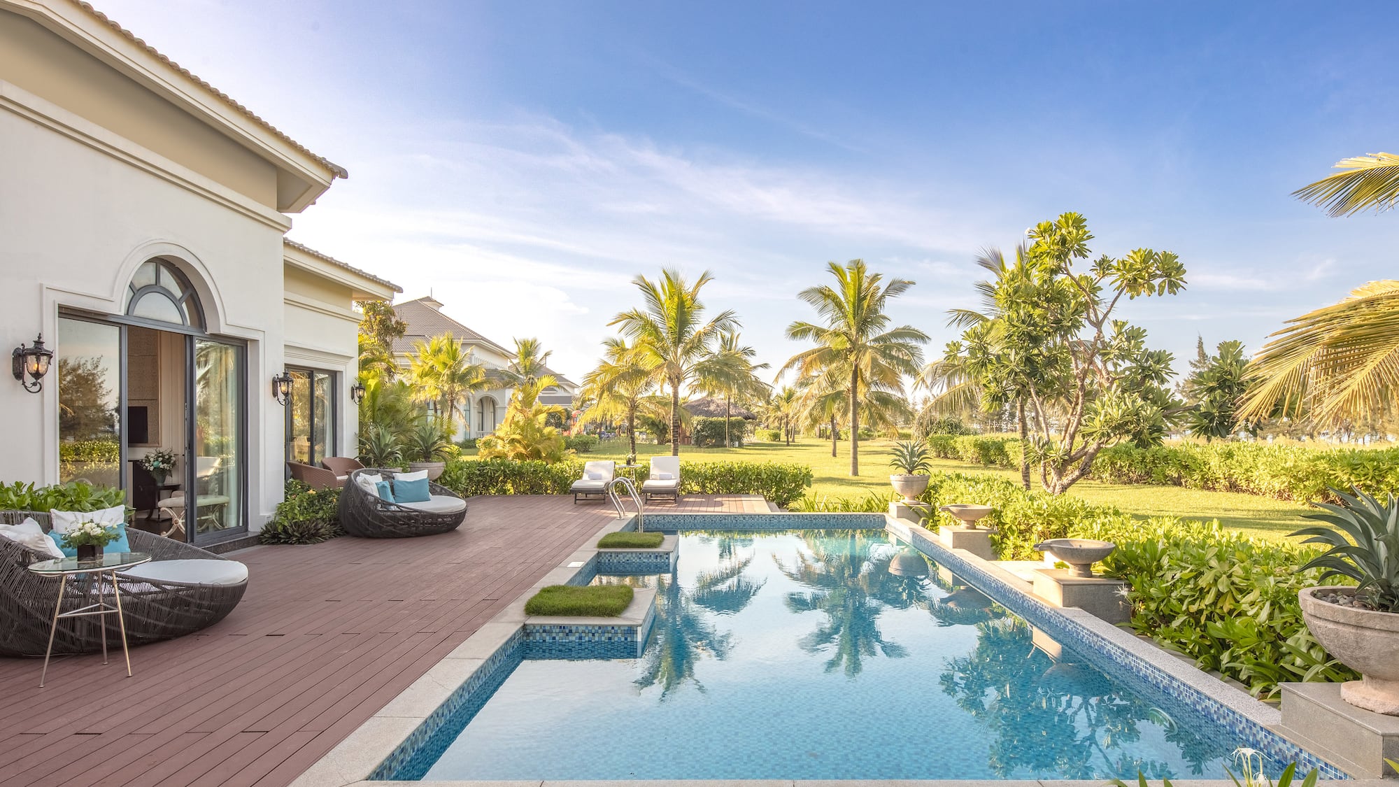 a pool with a deck and trees in the back