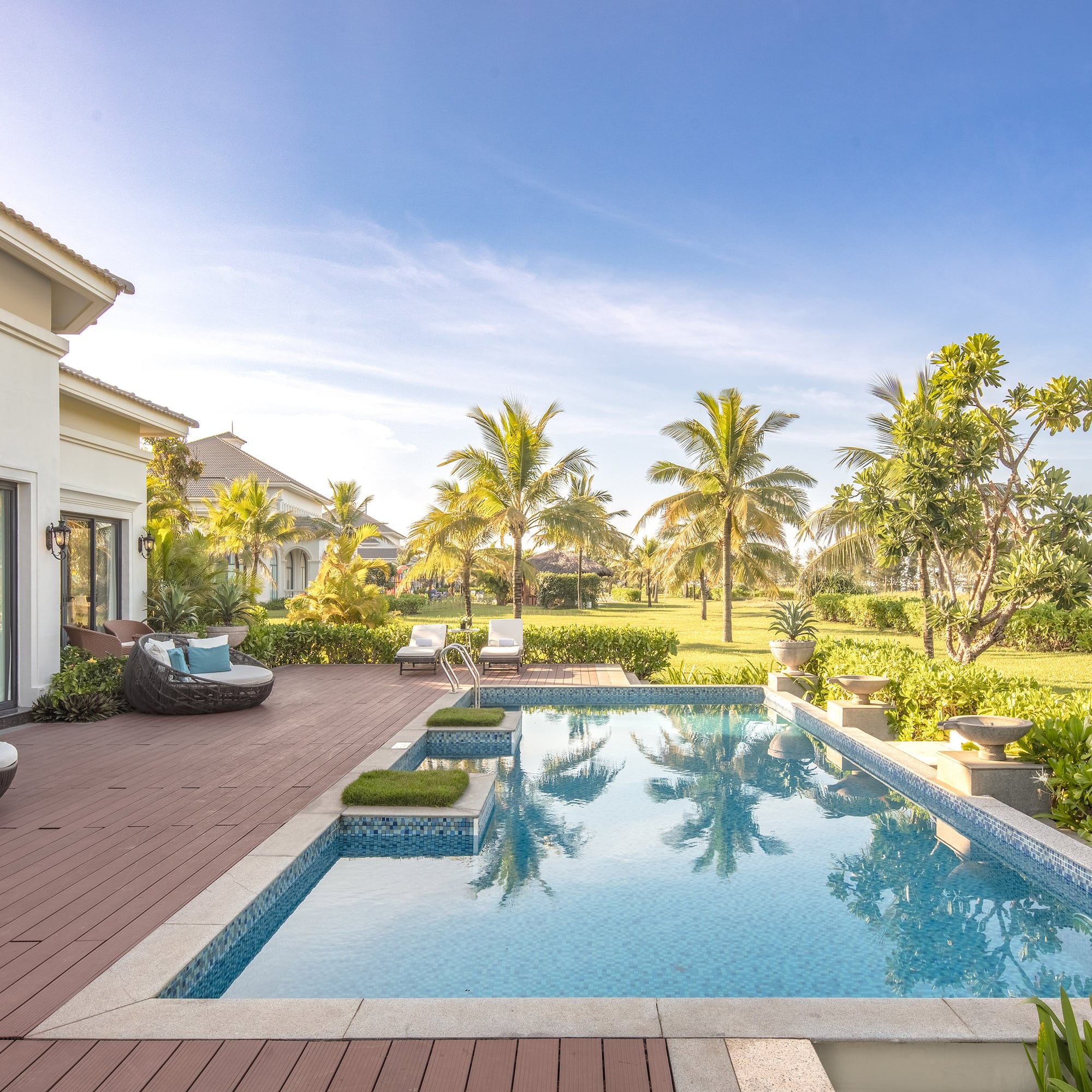 a pool with a deck and trees in the back