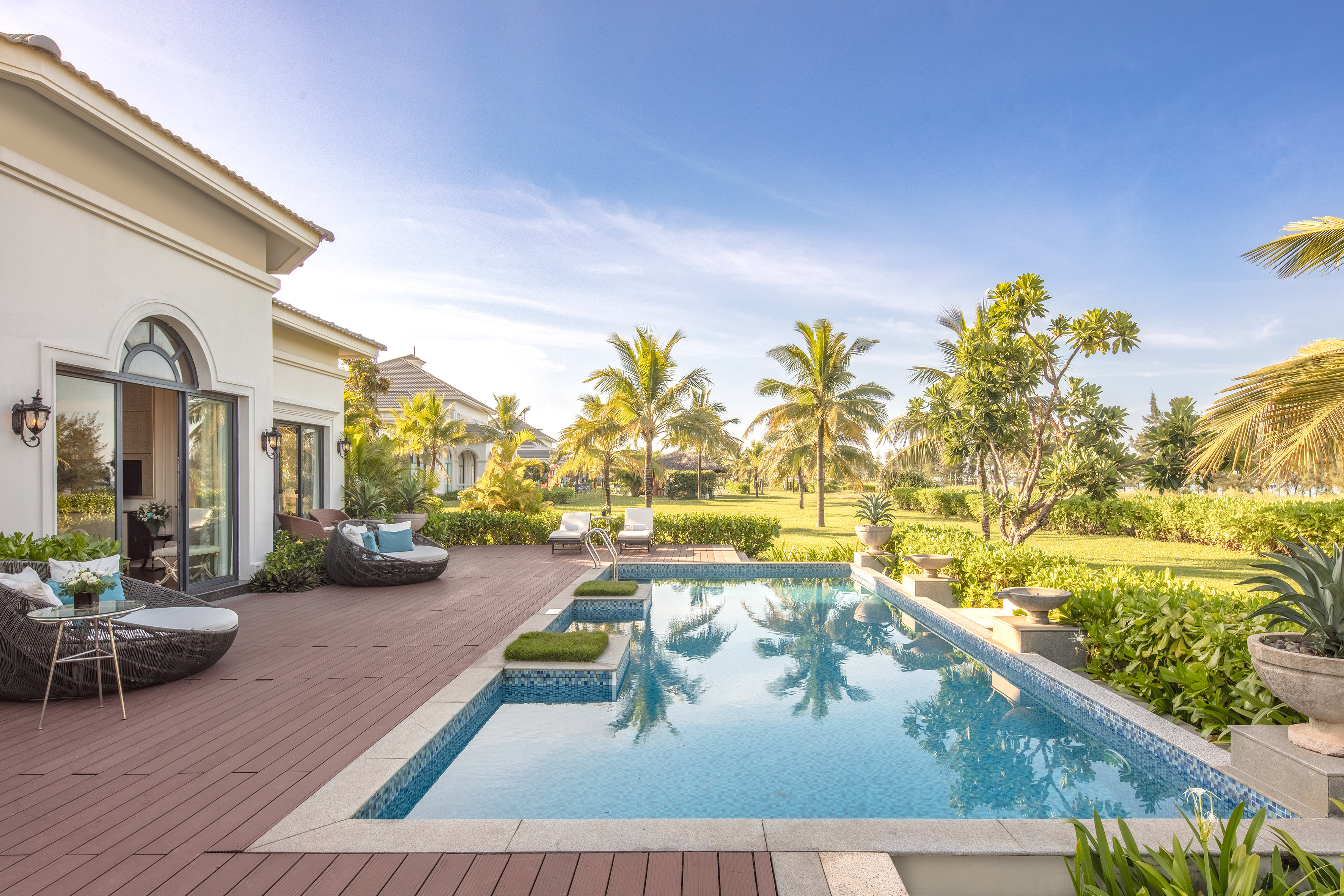 a pool with a deck and trees in the back