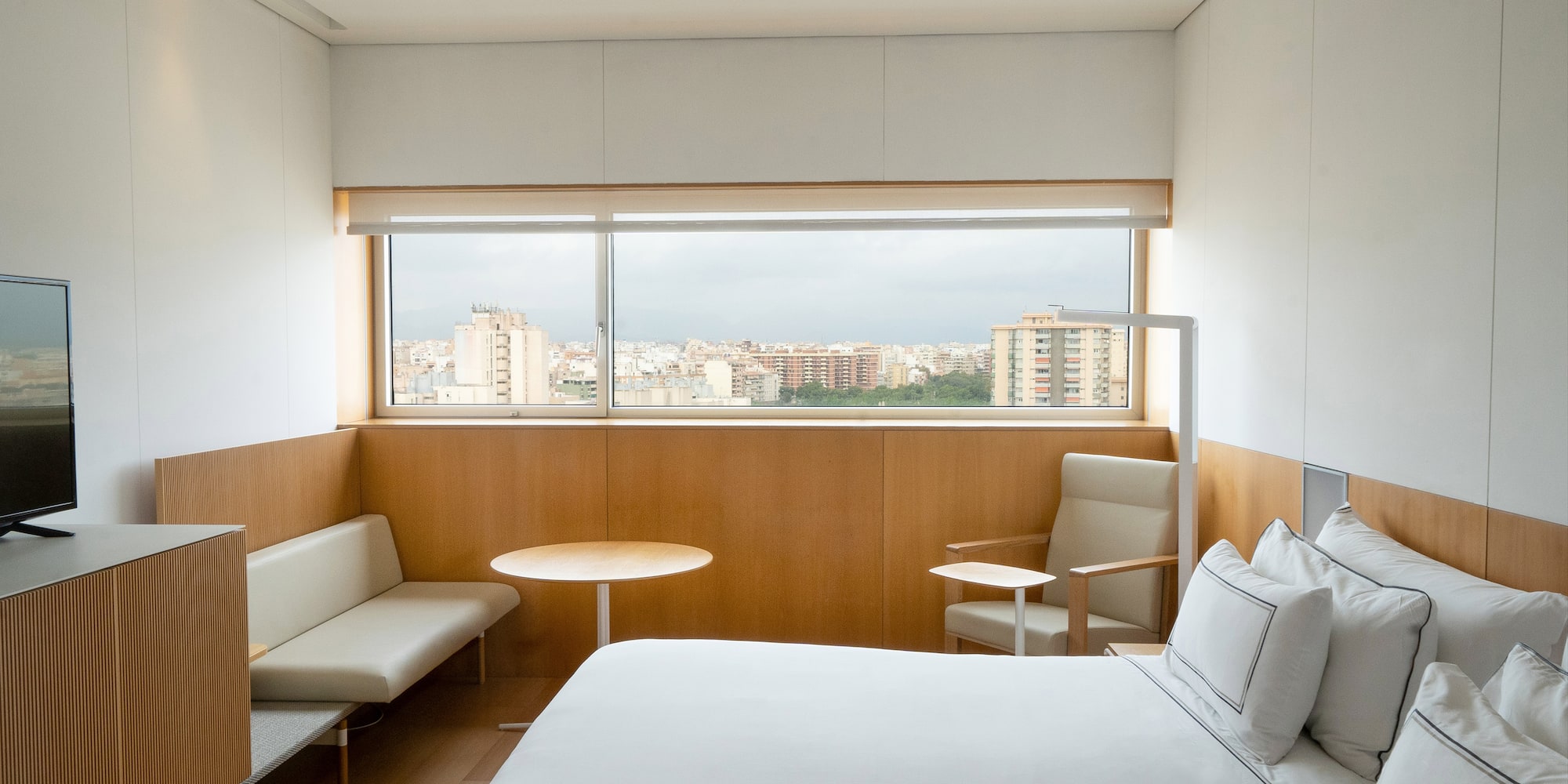 a room with a bed and a table and chairs