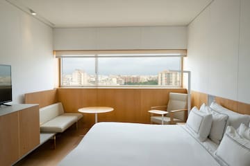 a room with a bed and a table and chairs