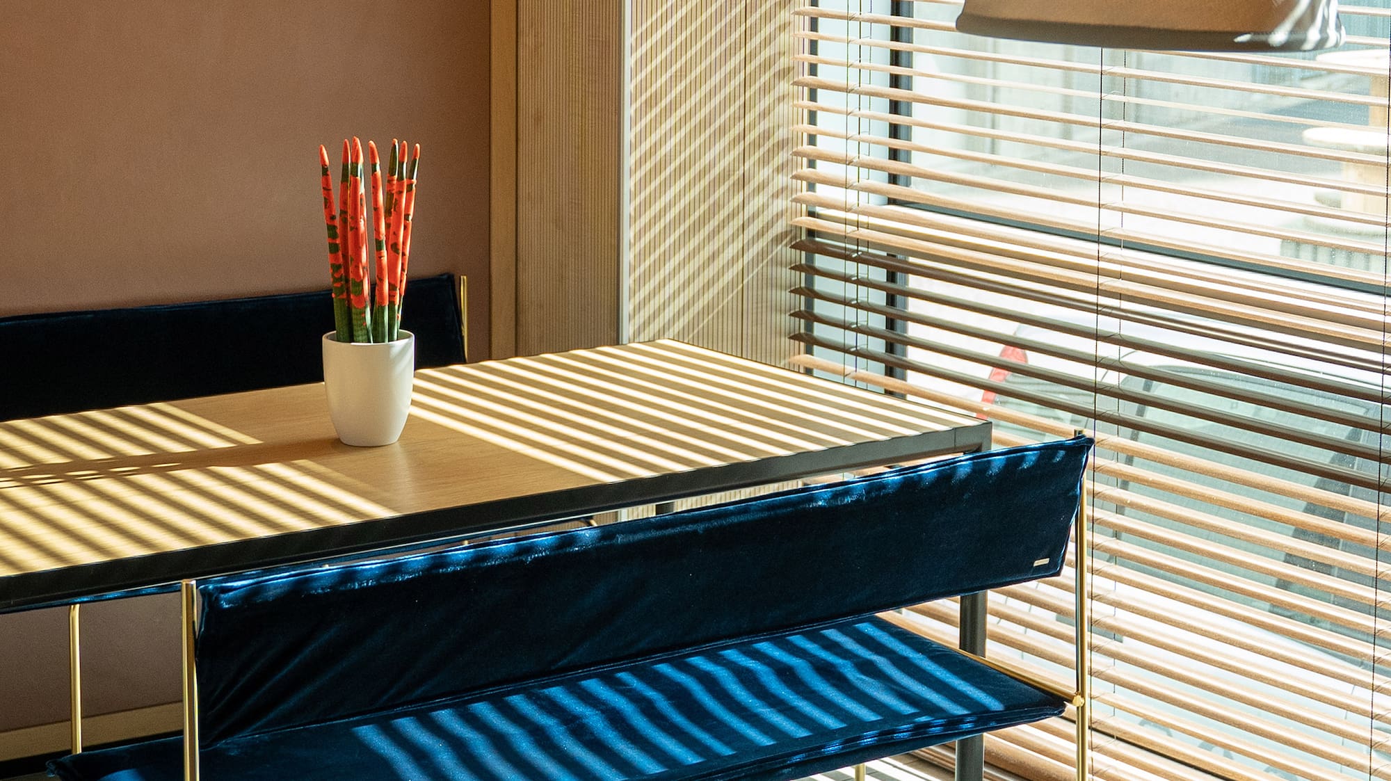 a table with blue cushions and a lamp in front of a window