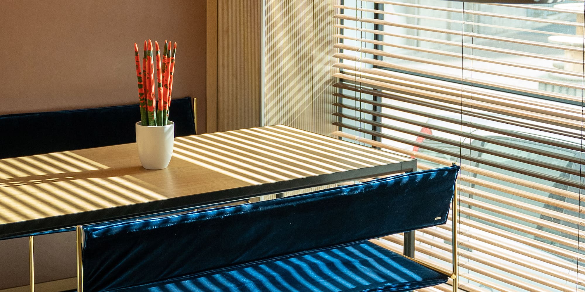 a table with blue cushions and a lamp in front of a window