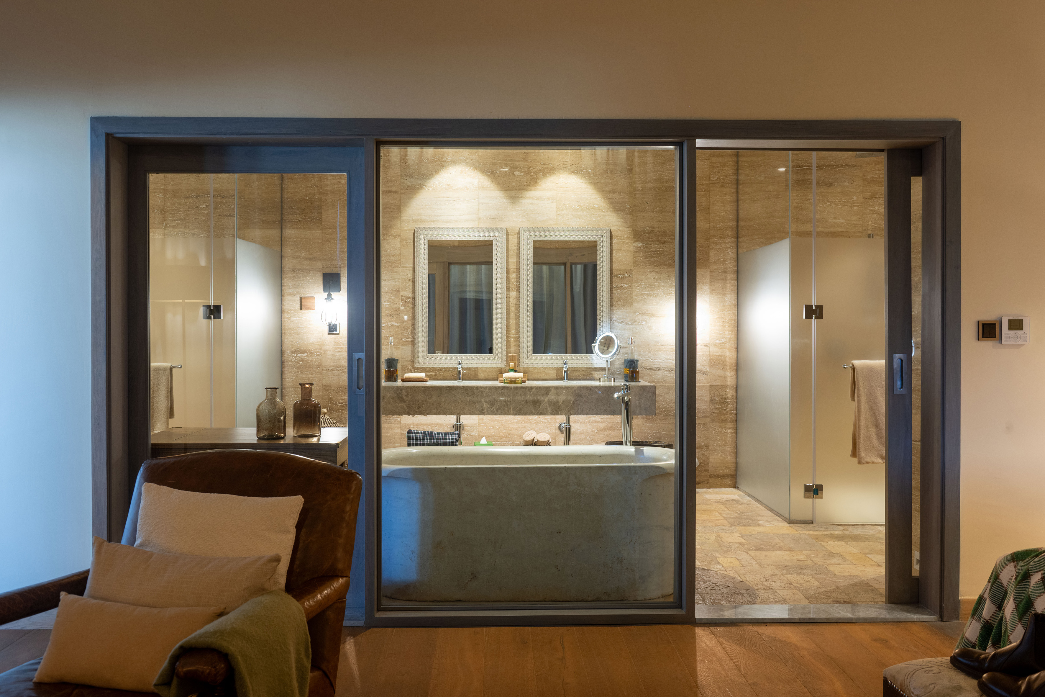 Contemporary bathroom with concrete tub, double vanity, glass shower, travertine.