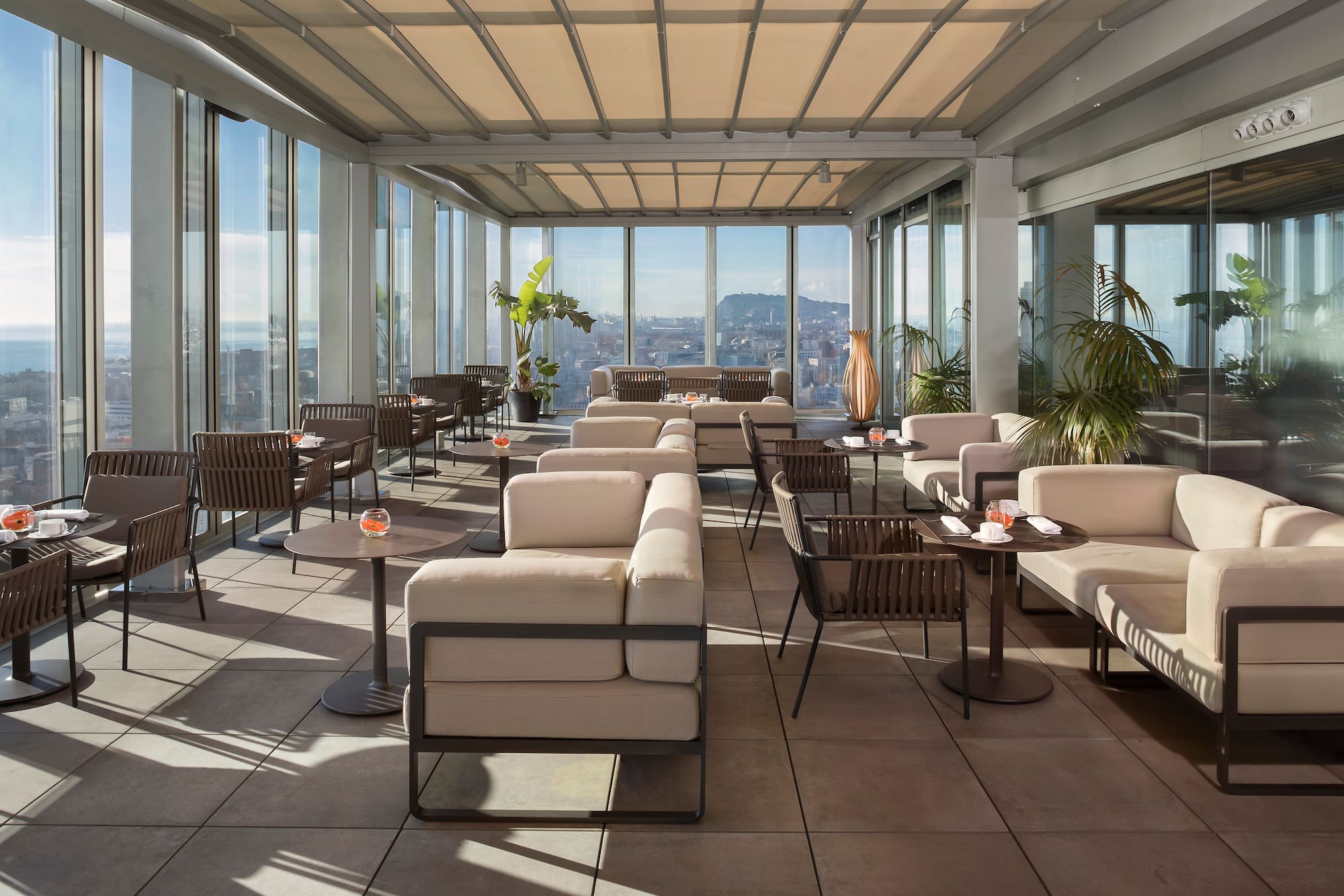 Rooftop bar terrace with panoramic city views and stylish outdoor seating.