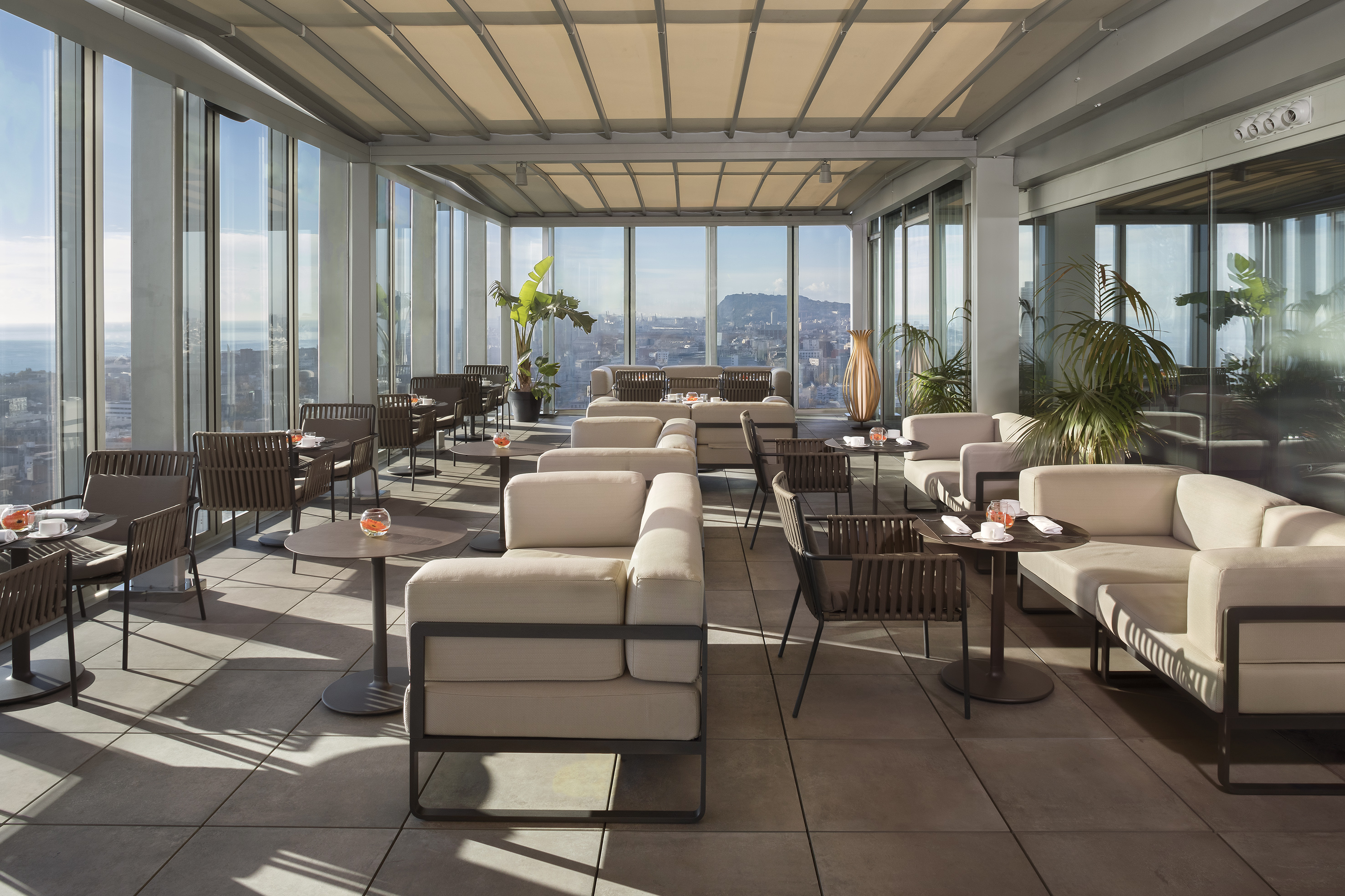 Rooftop bar terrace with panoramic city views and stylish outdoor seating.