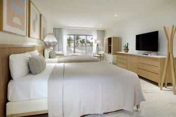 a bedroom with two beds and a television