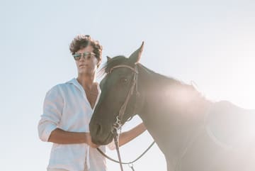 a man standing next to a horse