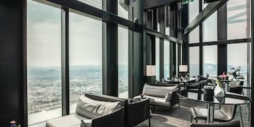 a room with chairs and tables and a view of a city