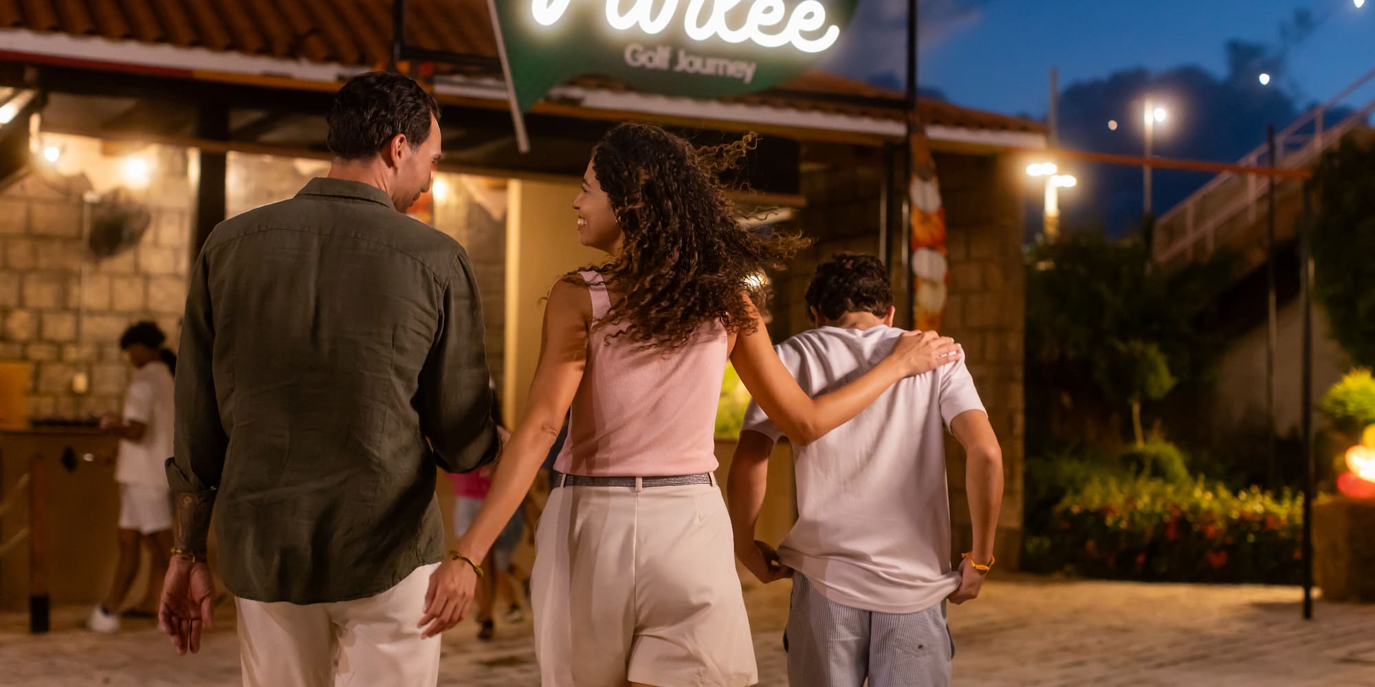 a group of people walking in front of a sign
