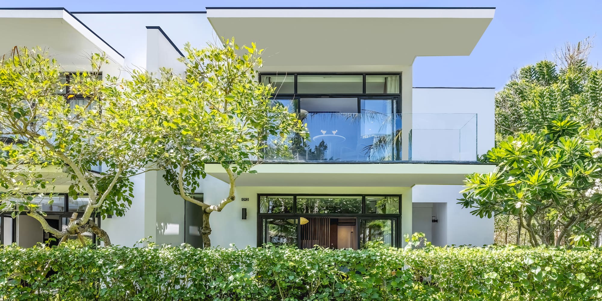 a white house with trees and bushes