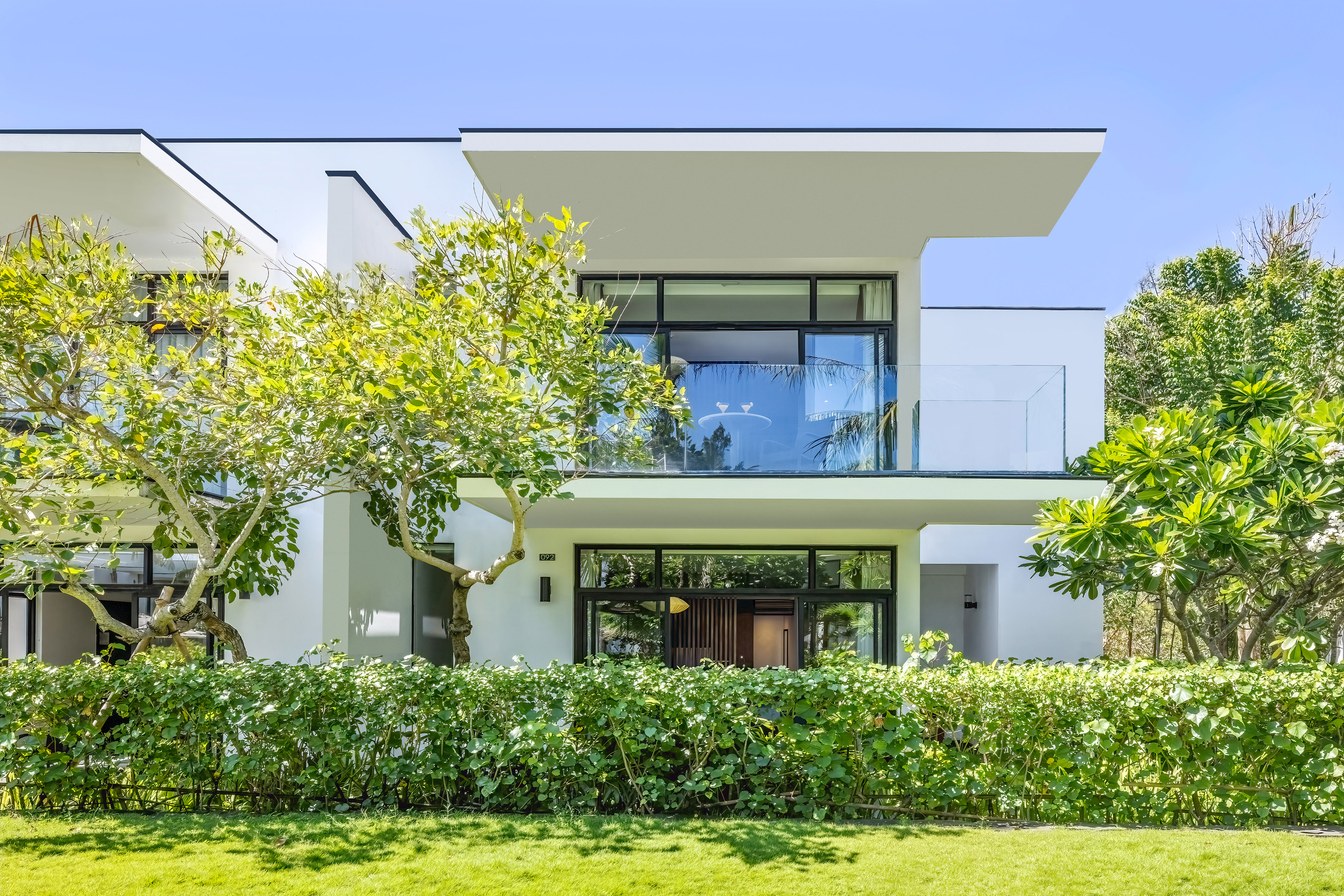 a white house with trees and bushes