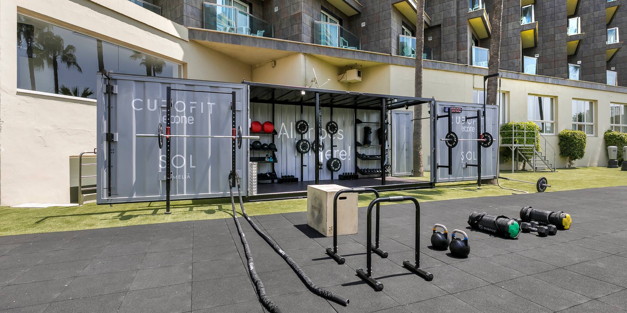 Sol Melia outdoor container gym with fitness equipment on artificial turf.