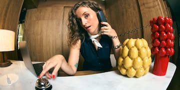 a woman sitting at a desk with a laptop and phone