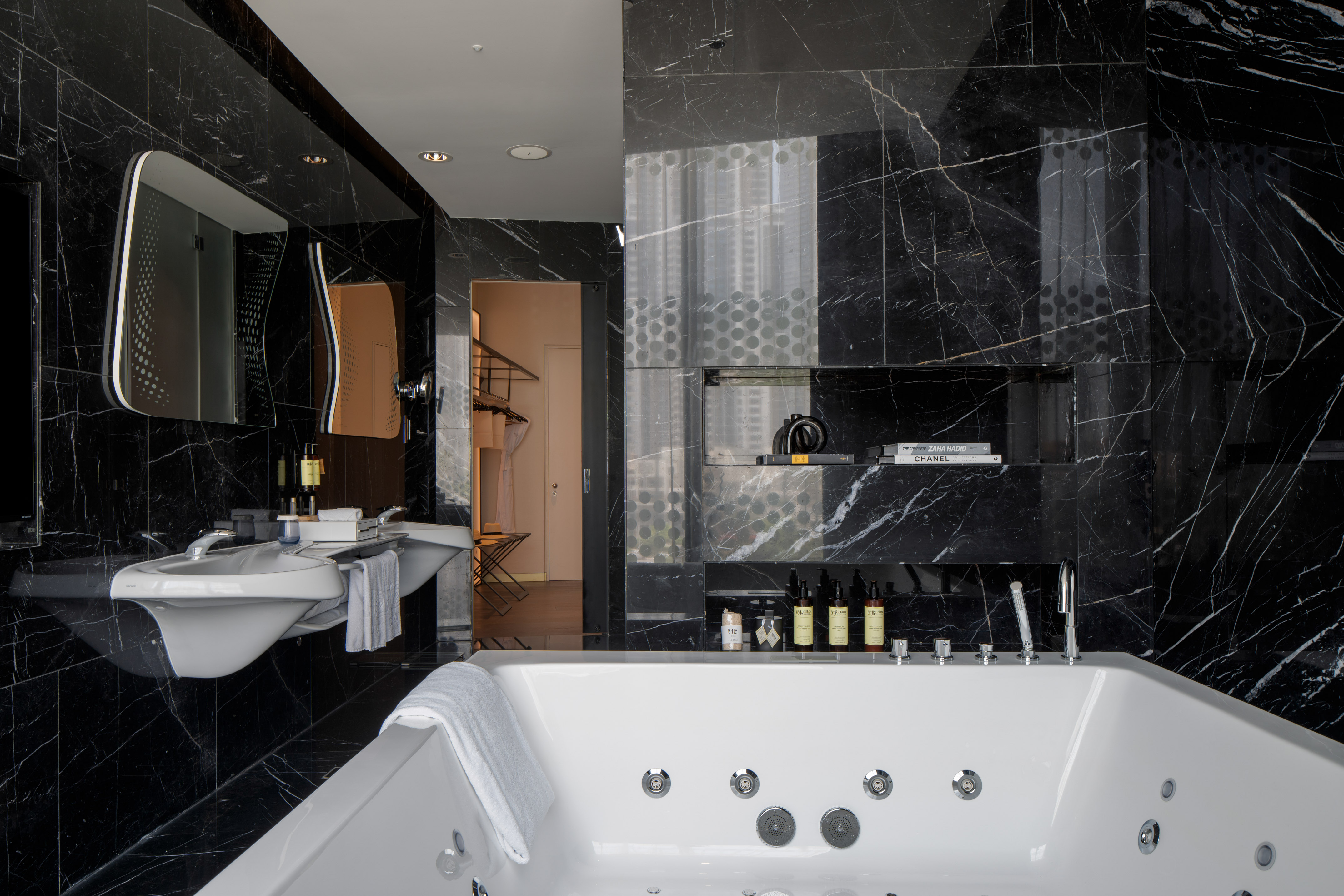 Chic black marble bathroom featuring a jacuzzi tub and sleek double vanity.