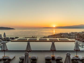 a pool with umbrellas and chairs overlooking a body of water