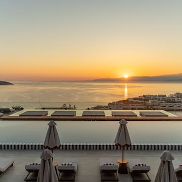 a pool with umbrellas and chairs overlooking a body of water