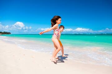 a boy and girl running on a beach