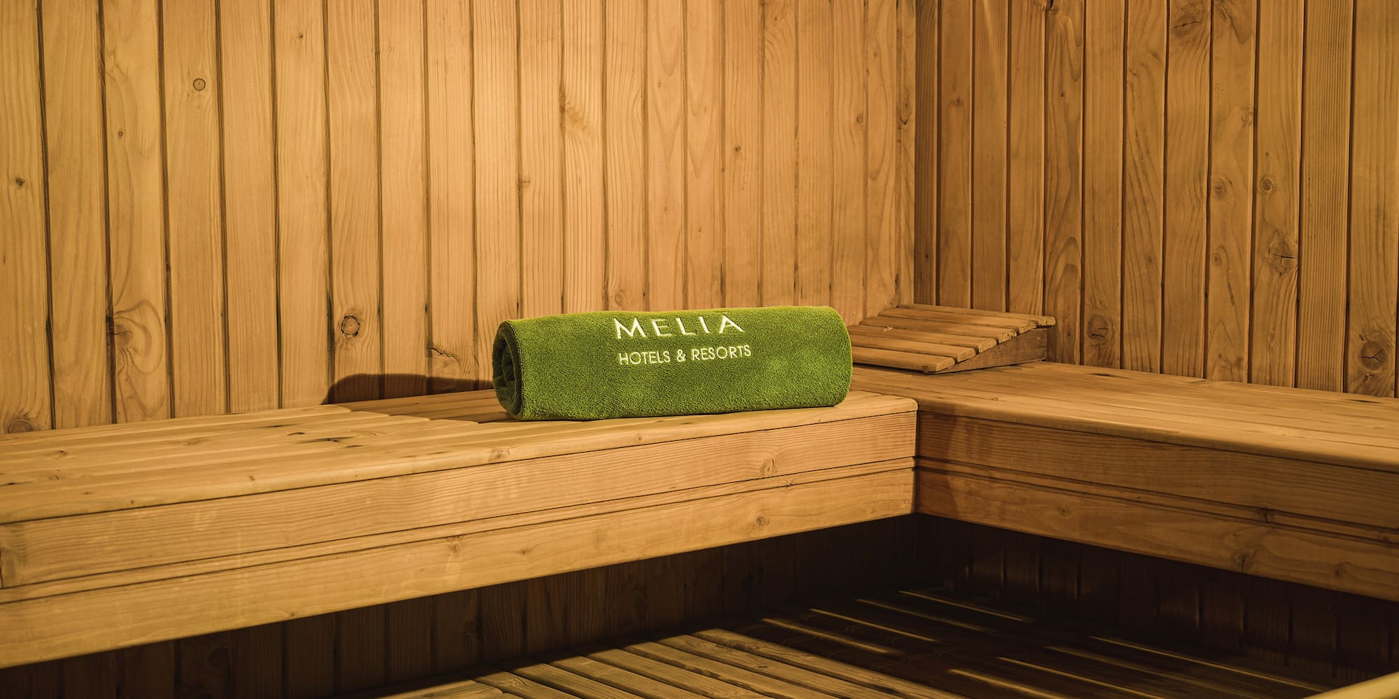 a wooden sauna with a bowl and a towel
