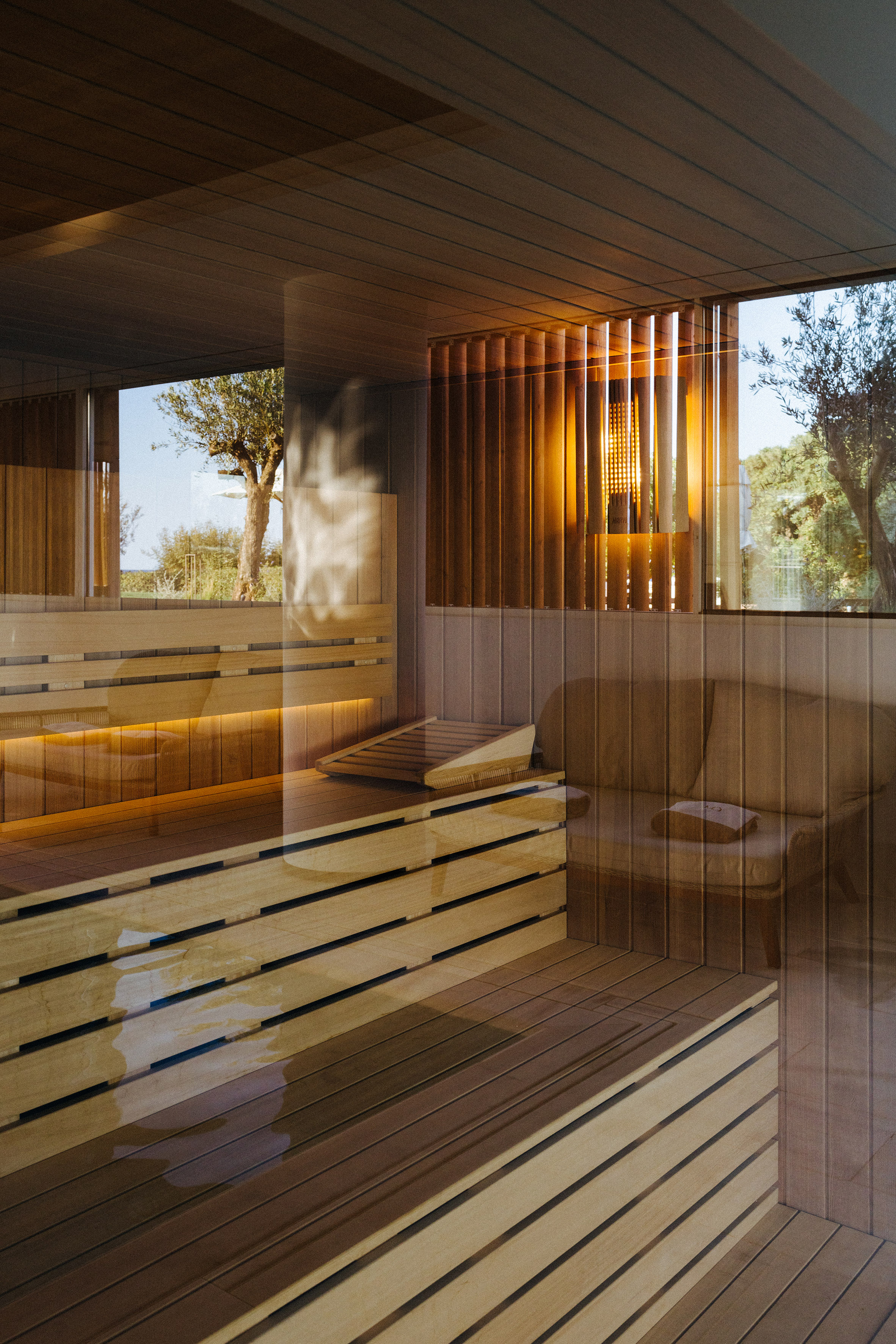 Modern wooden sauna with warm lighting and natural outdoor view.