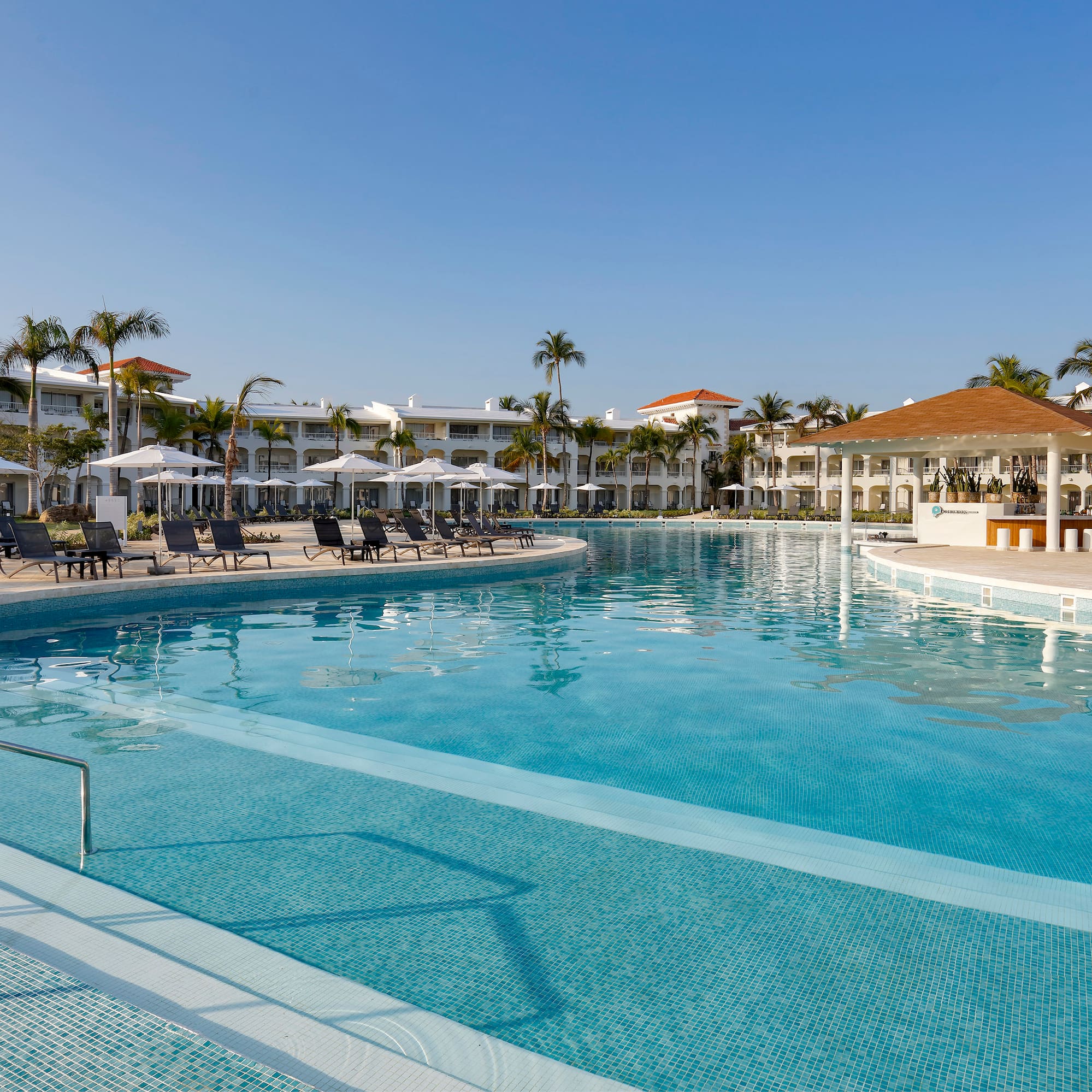 a swimming pool with lounge chairs and a building