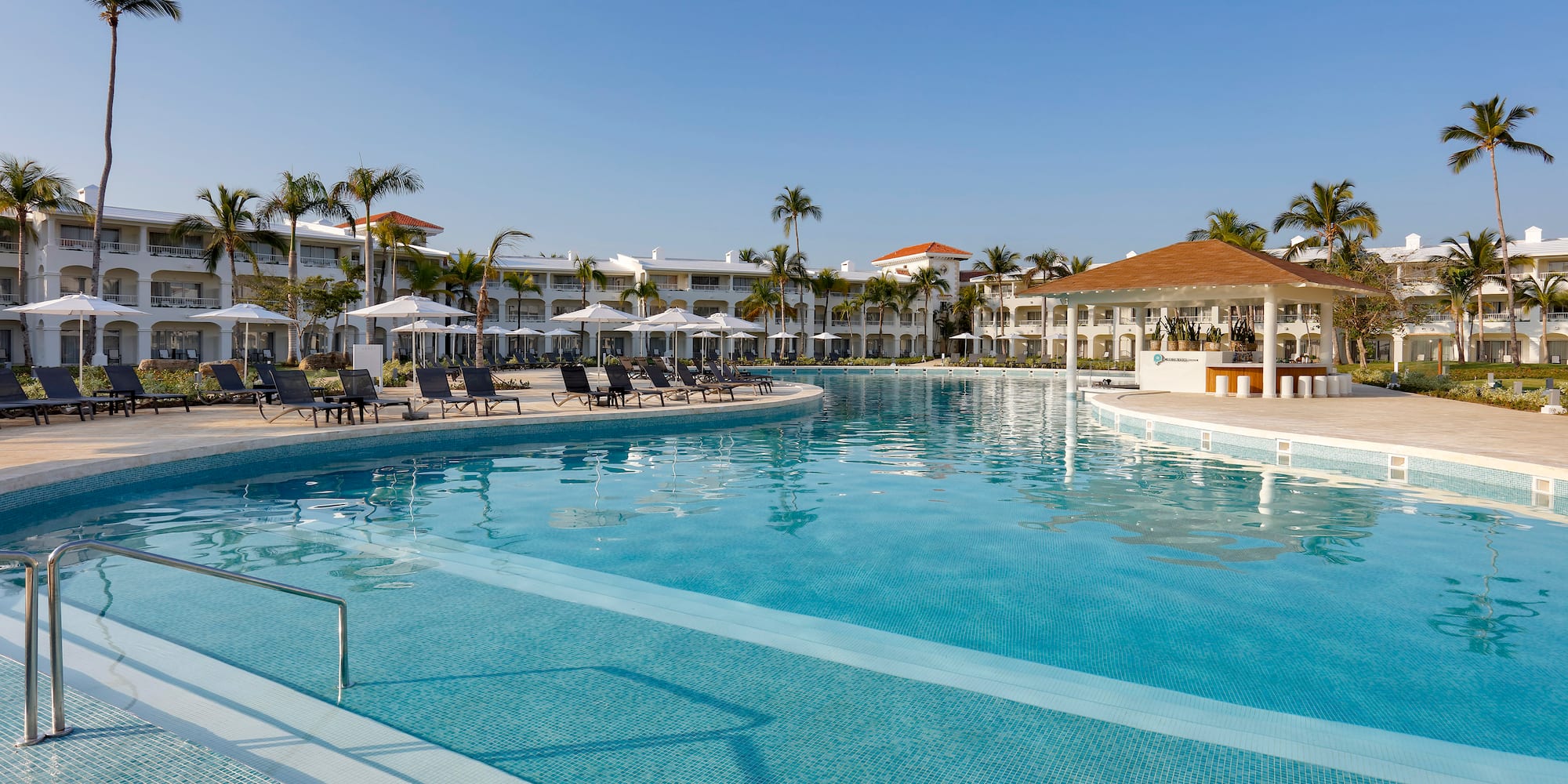 a swimming pool with lounge chairs and a building