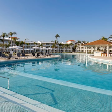 a swimming pool with lounge chairs and a building