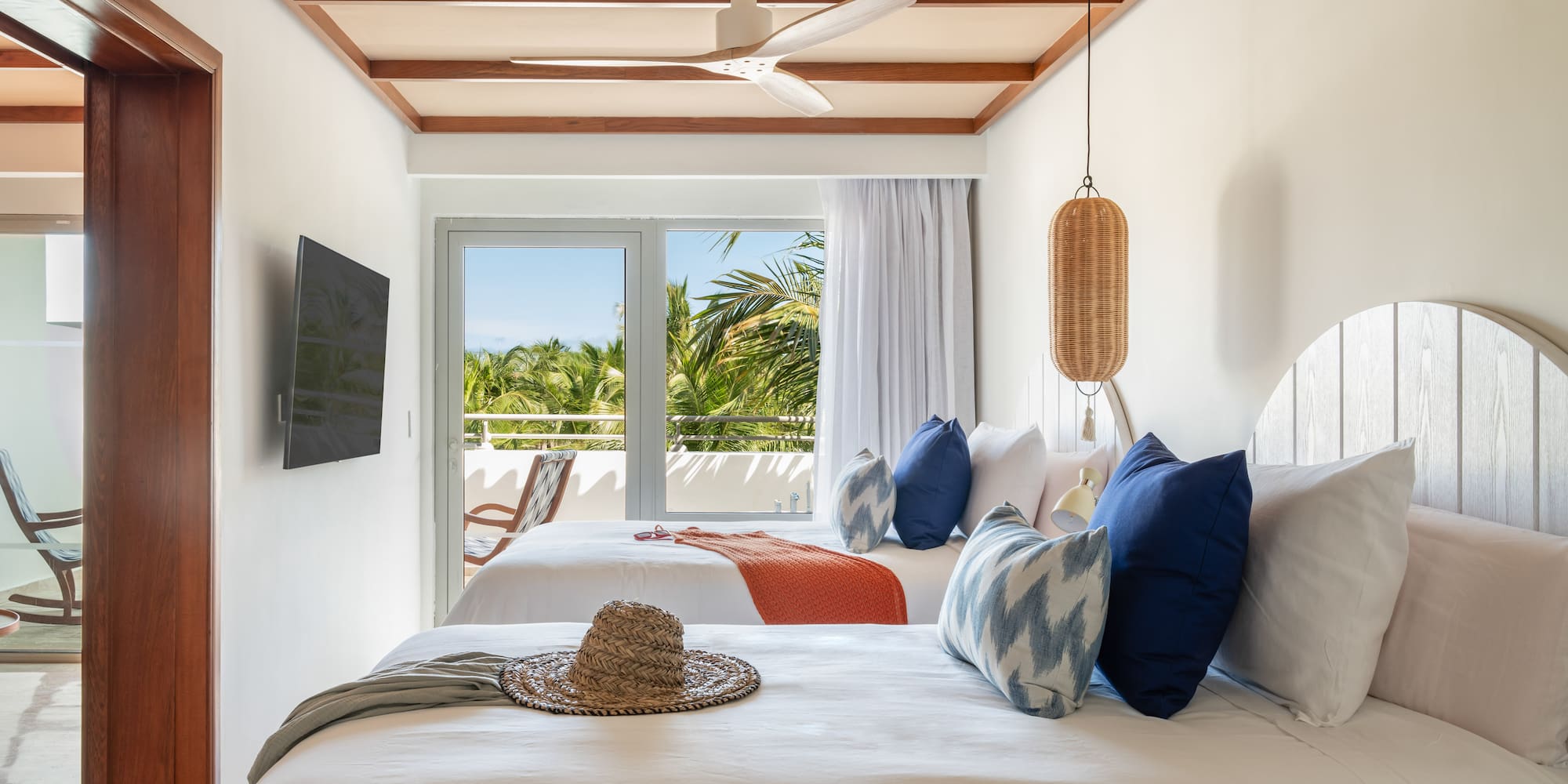 a room with two beds and a fan