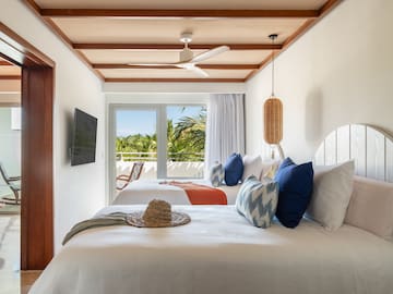 a room with two beds and a fan